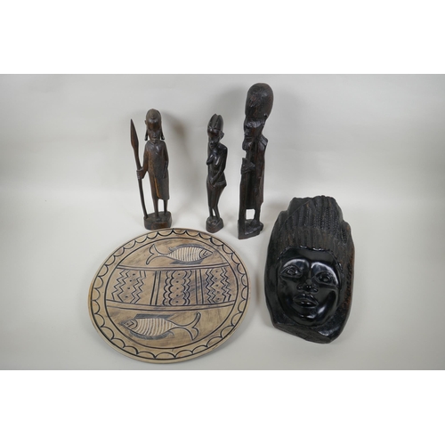 216 - Three African carved hardwood figures, an African carved hardwood wall mask and a soapstone charger ... 