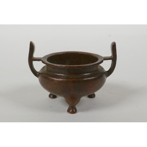 228 - A Chinese bronze two handled censer raised on tripod supports, Xuan character mark to base, 5cm diam... 