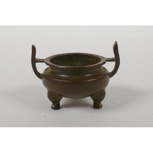 228 - A Chinese bronze two handled censer raised on tripod supports, Xuan character mark to base, 5cm diam... 