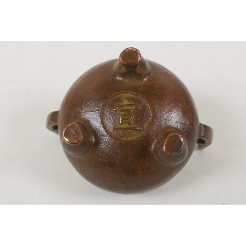 228 - A Chinese bronze two handled censer raised on tripod supports, Xuan character mark to base, 5cm diam... 