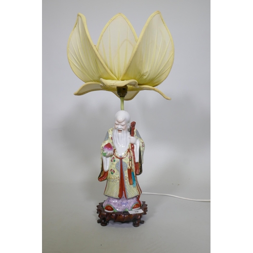 242 - A Chinese porcelain table lamp in the form of Shao Lao holding a peach and staff with dragon's head,... 