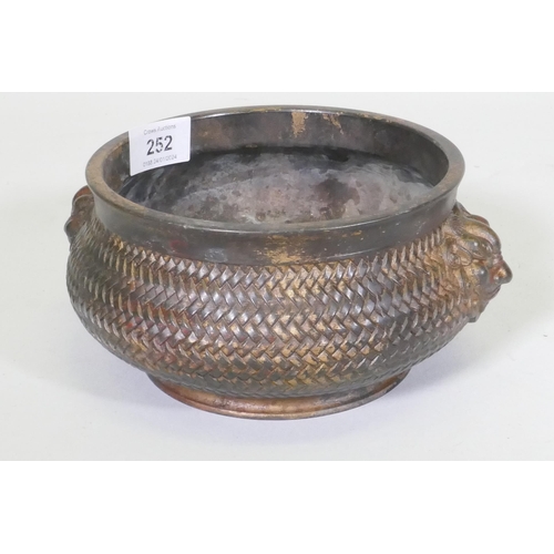 252 - A Chinese bronze censer with mask decoration and woven basket style body, impressed seal mark to bas... 