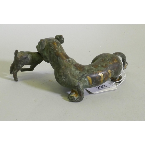 253 - An Eastern bronze figure of a lion with prey, 20 x 7cm high