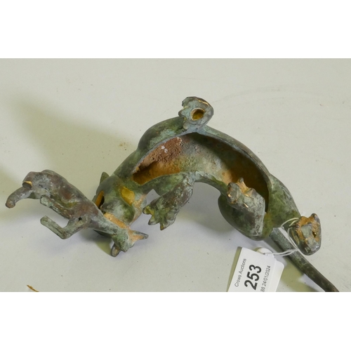 253 - An Eastern bronze figure of a lion with prey, 20 x 7cm high