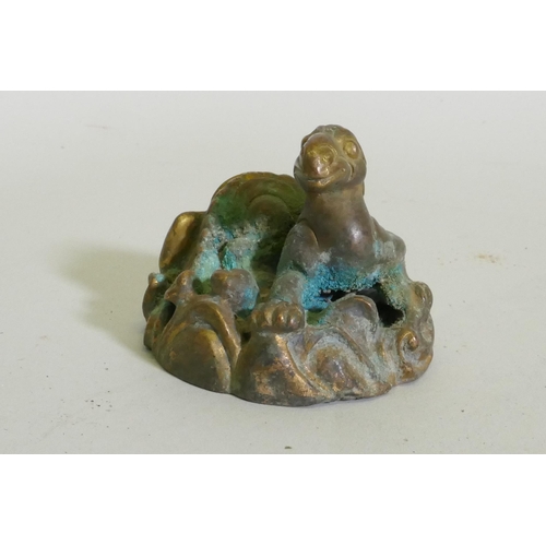 259 - An Eastern bronze figure of a horned dragon, 5cm high