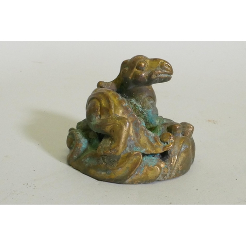 259 - An Eastern bronze figure of a horned dragon, 5cm high