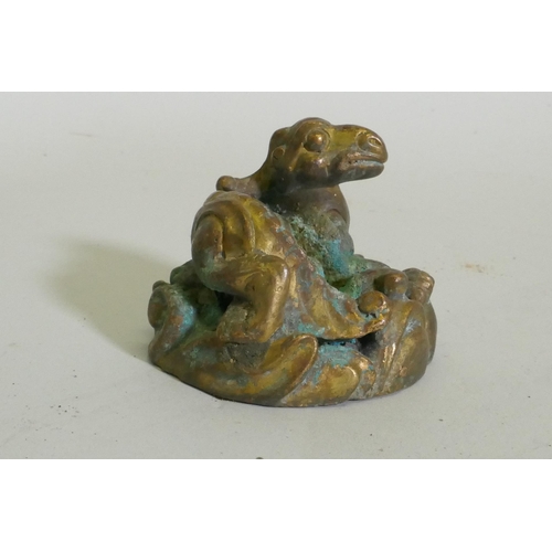 259 - An Eastern bronze figure of a horned dragon, 5cm high