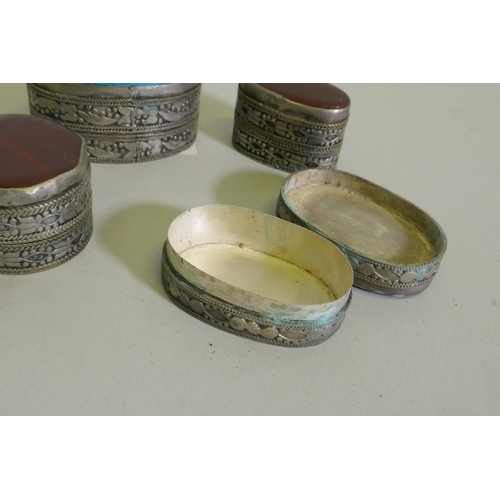 260 - Three white metal pill boxes with inset agate tops, largest 4.5cm long, and another with turquoise t... 