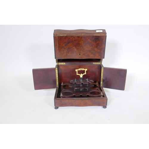 34 - A C19th amboyna and ebony serpentine front decanter case, the lift up top and fold out sides opening... 