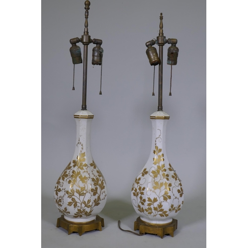 37 - A pair of vintage French Paris porcelain table lamps with gilded decoration, mounted on ormolu bases