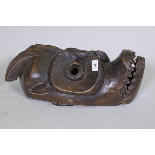 44 - An African tribal carved wood horned mask with hinged jaw, 50cm long, AF minor loss and break