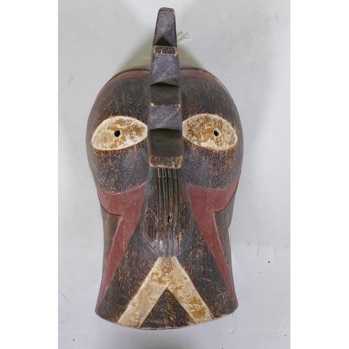 47 - An African tribal carved and painted wood mask in the form of a cockerel, 36cm long