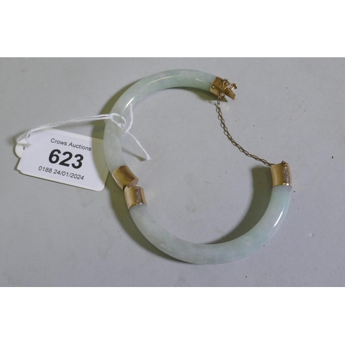 623 - A jade bangle with 9ct gold mounts, 5.5cm internal diameter