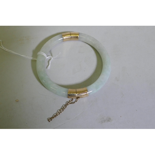 623 - A jade bangle with 9ct gold mounts, 5.5cm internal diameter