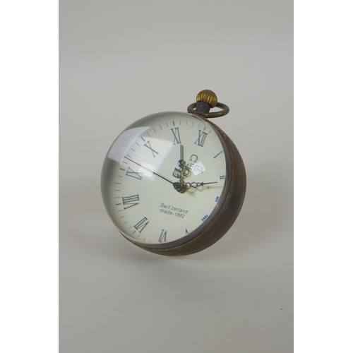 626 - A brass bound glass ball clock, 6cm diameter