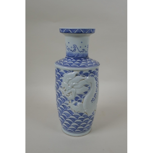 63 - A Chinese blue and white porcelain vase with raised dragon decoration, impressed mark to base, 24cm ... 