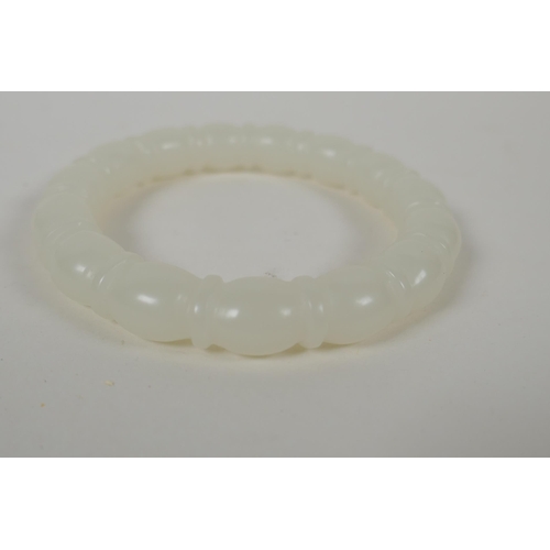 635 - A carved white hardstone bangle, 7.5cm diameter