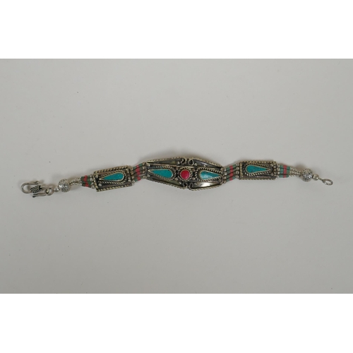 643 - A Tibetan white metal bracelet set with turquoise and coral shards, together with four similar penda... 