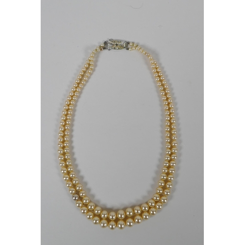 665 - A vintage graduated faux pearl twin strand necklace, 38cm long