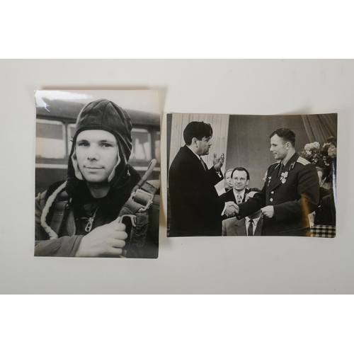 67 - Two vintage press photos of Yuri Gagarin, with archival stamps and typed Cyrillic descriptions verso... 