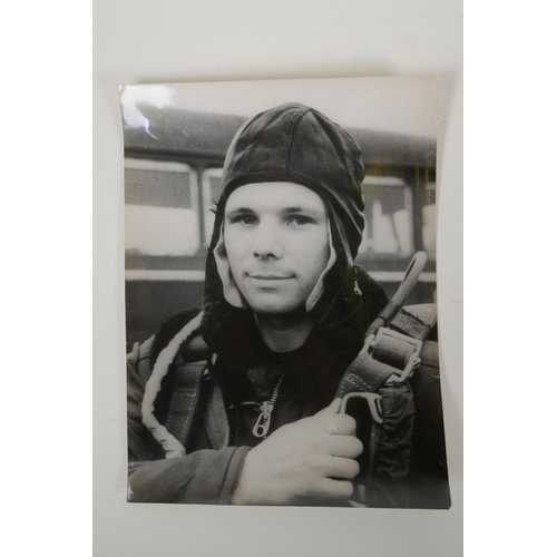 67 - Two vintage press photos of Yuri Gagarin, with archival stamps and typed Cyrillic descriptions verso... 