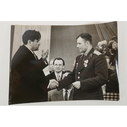 67 - Two vintage press photos of Yuri Gagarin, with archival stamps and typed Cyrillic descriptions verso... 