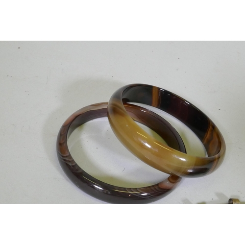 673 - A pair of agate bangles, 16.3cm internal diameter, and an agate pendant in metal mount