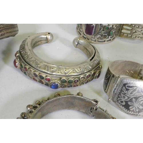 674 - A collection of Afghan white metal bangles, set with paste stones, bidri style decoration, a Chinese... 