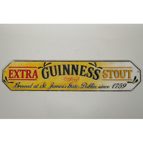 76 - A cold painted cast iron 'Guinness Extra Stout' sign, 56cm long