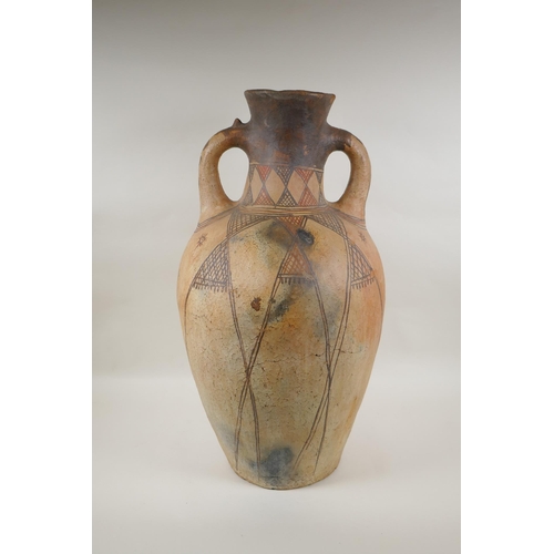 84 - An antique North African terracotta amphora with two handles and hand painted design, AF, 63cm high