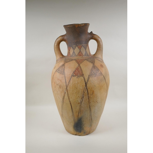 84 - An antique North African terracotta amphora with two handles and hand painted design, AF, 63cm high