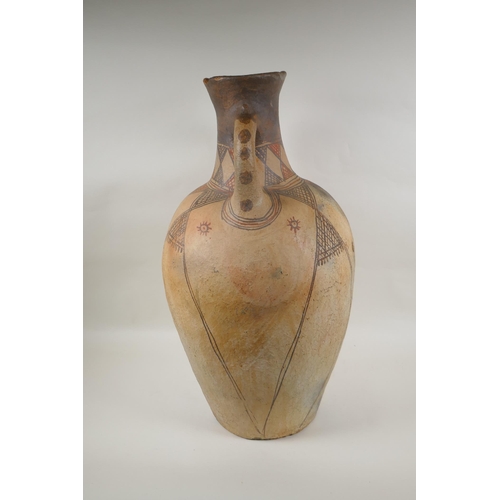 84 - An antique North African terracotta amphora with two handles and hand painted design, AF, 63cm high