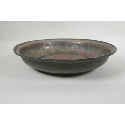 85 - An antique Islamic copper dish with chased script and floral decoration, 34cm diameter