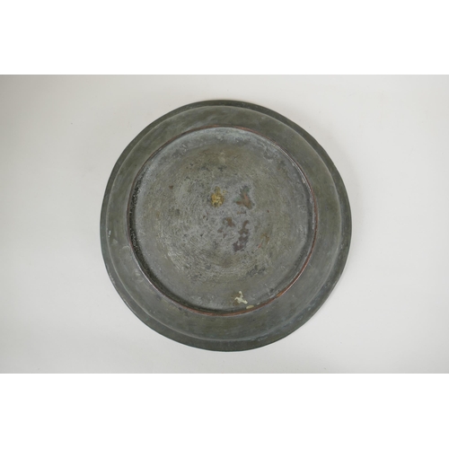 85 - An antique Islamic copper dish with chased script and floral decoration, 34cm diameter