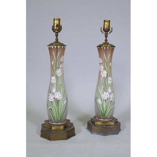 92 - A pair of opaline glass table lamps with hand painted enamel decoration, raised on metal bases, 56cm... 