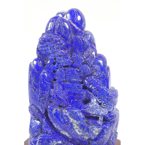 97 - A large Chinese lapis lazuli carving of a mountain side village, on a wood stand, 22cm high