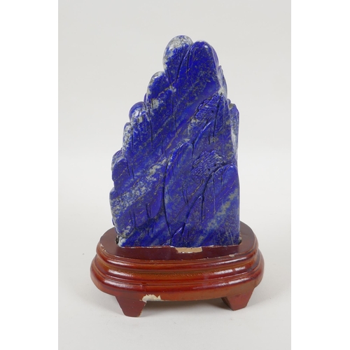 97 - A large Chinese lapis lazuli carving of a mountain side village, on a wood stand, 22cm high