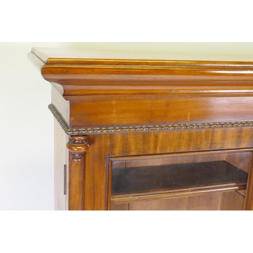 1139 - A C19th mahogany bookcase with moulded frieze over two glazed doors, raised on a plinth base, 111 x ... 