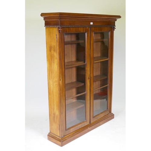 1139 - A C19th mahogany bookcase with moulded frieze over two glazed doors, raised on a plinth base, 111 x ... 