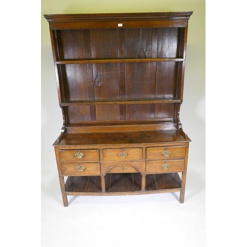 1140 - A good C18th Welsh oak dresser, the enclosed delf rack on a base of five drawers, the middle opening... 