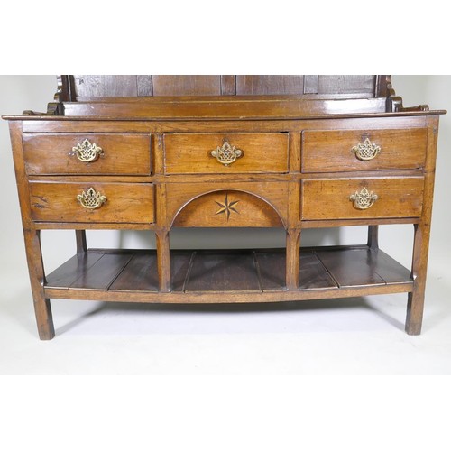 1140 - A good C18th Welsh oak dresser, the enclosed delf rack on a base of five drawers, the middle opening... 