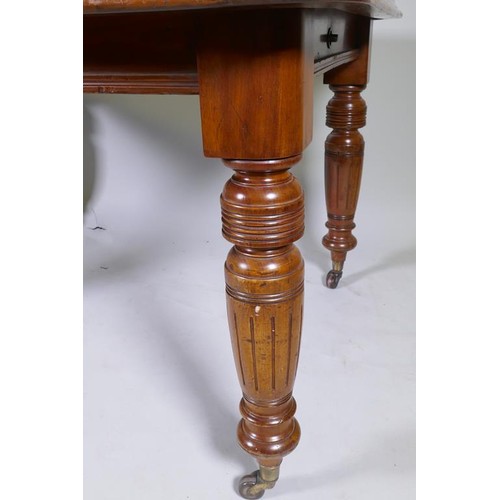 1141 - A Victorian mahogany wind out dining table with two extra leaves, raised on turned and fluted suppor... 