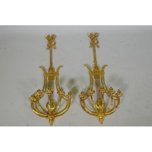 1003 - A pair of ormolu empire style five branch wall sconces of lyre form, 97cm high