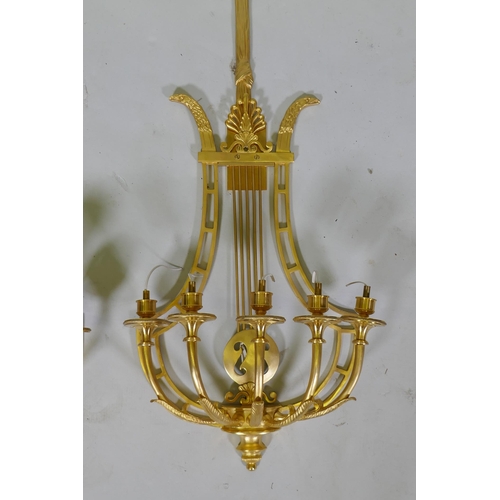 1003 - A pair of ormolu empire style five branch wall sconces of lyre form, 97cm high