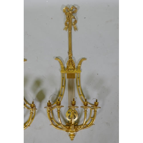 1003 - A pair of ormolu empire style five branch wall sconces of lyre form, 97cm high