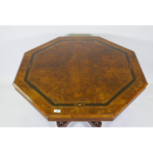 1004 - A Victorian inlaid walnut octagonal tilt top occasional table, raised on four turned columns and cab... 