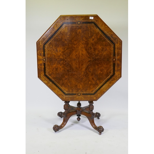 1004 - A Victorian inlaid walnut octagonal tilt top occasional table, raised on four turned columns and cab... 