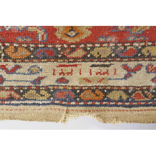 1018 - An antique Persian hand woven wool carpet, with medallion design on a red and blue field with ivory ... 