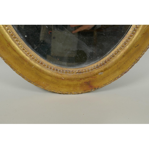 1022 - An antique French oval gilt mirror, with bevelled antique glass, 53 x 87cm