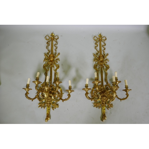 1034 - A pair of ormolu five branch sconces decorated with swags, masks and torches etc 119cm 